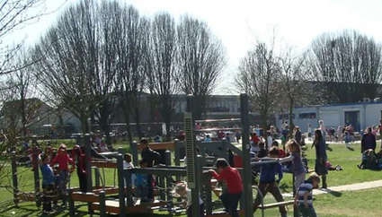 Grote groep kinderen aan het spelen in speeltuin.