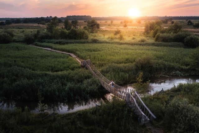 Een man loopt over een loopbrug over Het Dommelpad.