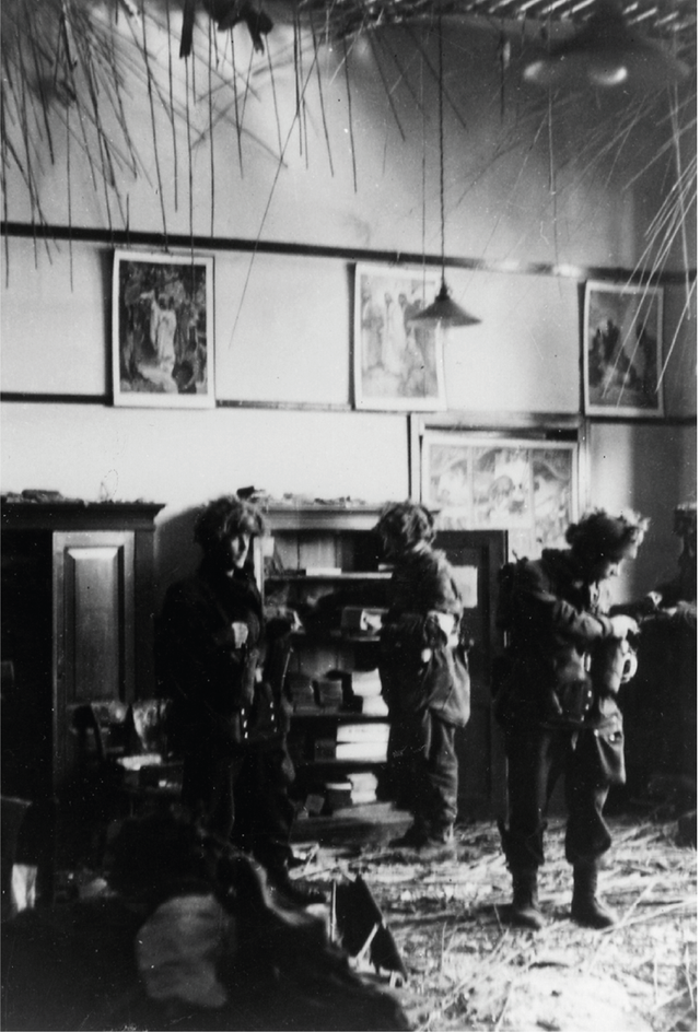 Polish doctors and nurses, dressed in flak jackets as protection from the German shootings, help the wounded in the field hospital in the school.