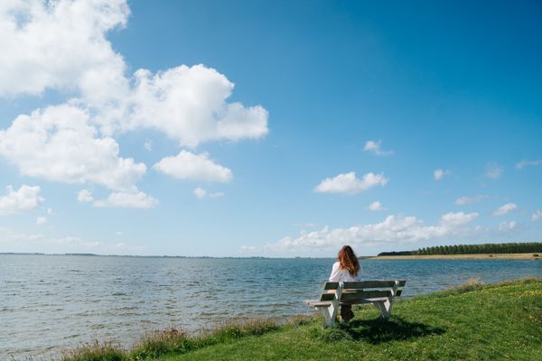 Vrouw kijk uit over het water bij het havengebied van Herkingen