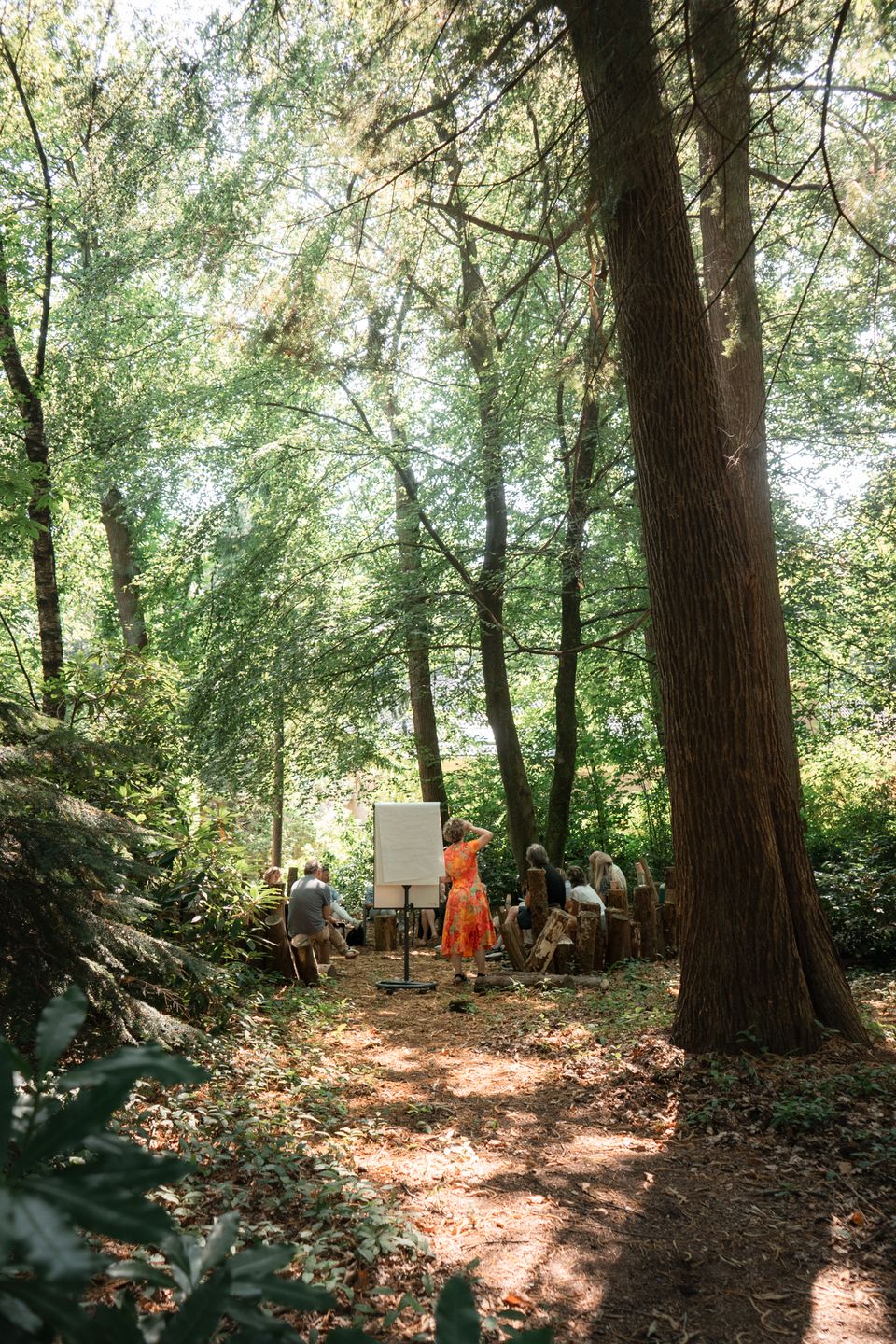 Een flipover met een groep mensen midden in het bos. De zon schijnt door de bomen en het is groen.
