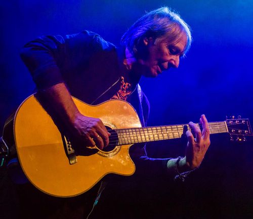 Een man die op een gitaar aan het spelen is