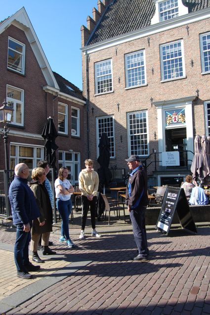 Stadswandeling met gids in Montfoort, provincie Utrecht, in het Groene Hart, waarbij een groep bezoekers voor het historische Oude Stadhuis luistert naar uitleg over de stad.