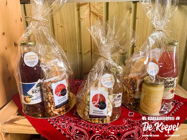 Landwinkel Kaasboerderij De Koepel, Harmelen, provincie Utrecht, Groene Hart, houten schap met streekproducten en geschenkverpakkingen met boerenkaas, appel-perensap, notenmix, yoghurtrozijnen en koolzaadhoning.