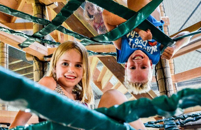 2 kinderen klauteren in het klimpark in de speelschuur van de Drentse Koe