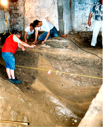 Onderzoek in de middeleeuwse kelder van Houtmarkt 69 in 2004. De V-vorm van de enorme Romeinse gracht is duidelijk te zien. (Bron: Groothedde 2013, 73)