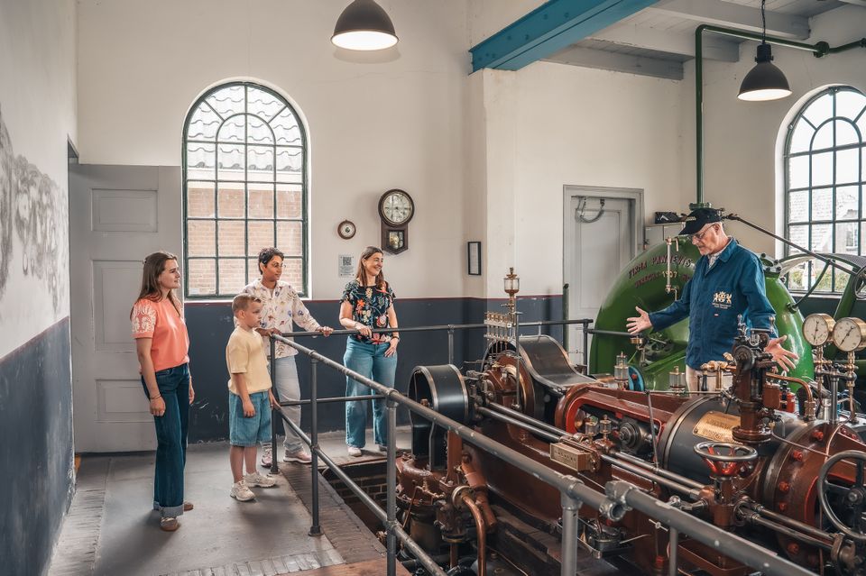 Bezoekerscentrum Stoomgemaal Teijlingens in Kamerik, Groene Hart, rondleiding langs historische stoommachine waarbij een gids bezoekers uitleg geeft over het industriële erfgoed en de werking van het gemaal.