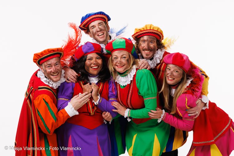 Foto van 6 pieten in kleurrijke kleding.