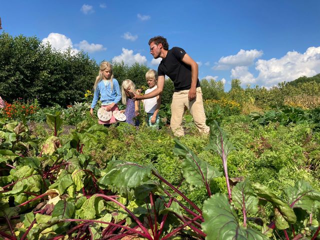 Vader met drie kinderen geniet van het buitenleven in de Proeftuin van Linschoten – een puur Hollands moment tussen het groen, dichtbij Woerden.