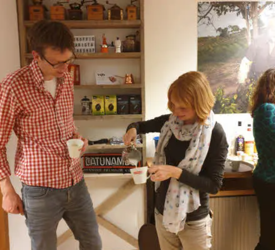 Twee deelnemers leren koffie bereiden tijdens een baristaworkshop bij WP Koffie & Thee Specialiteiten in Woerden.