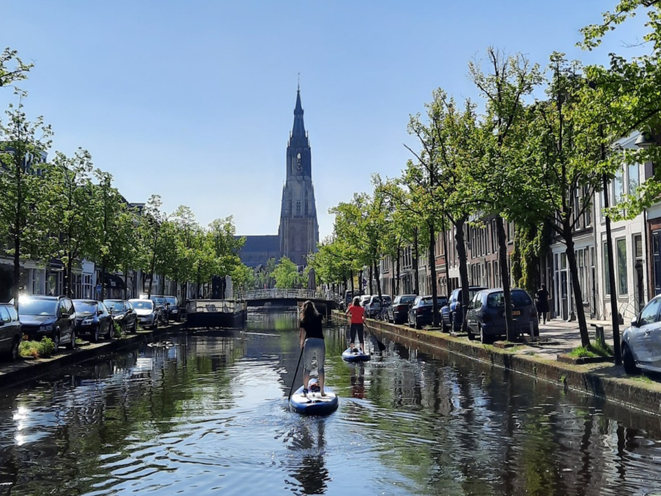 Twee dames die aan het suppen zijn in de grachten van Delft bij Sup & Surf