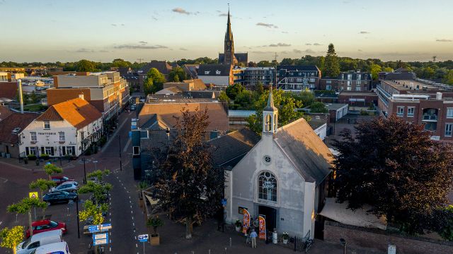 luchtfoto van wit kerkje en de straten van het dorp
