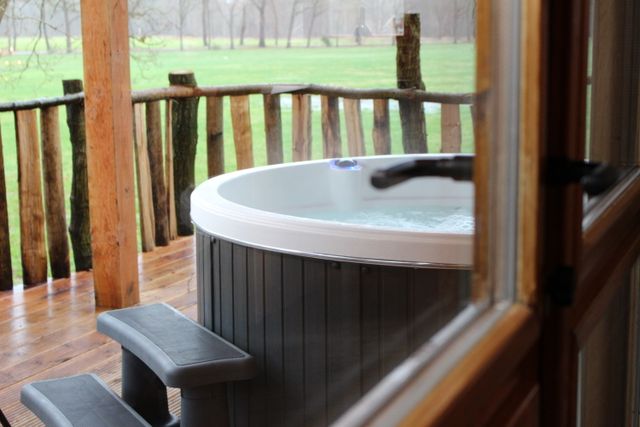 Een dampende jacuzzi op het terras van de boomhut.