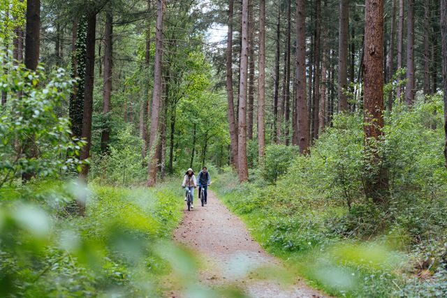 Stel fietst met hun ebikes door het bos