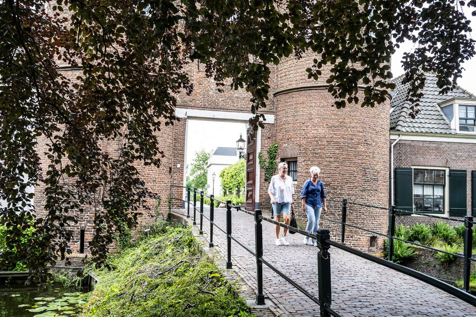 Dames wandelen over brug kasteel Montfoort