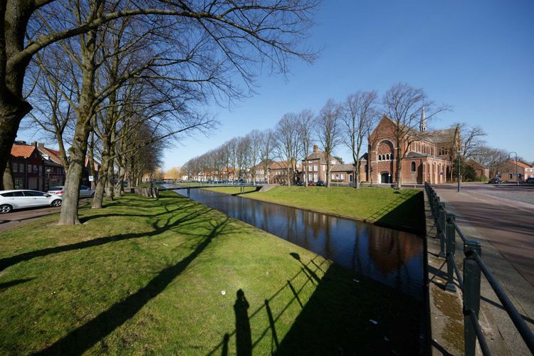 Foto van de Bottekreek in centrum Klundert met de Stad Klundert op de achtergrond