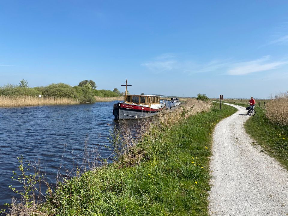 Fietsende vrouw langs de rivier de Tjonger