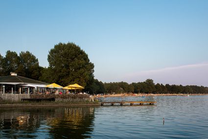Water met een restaurant op de kade en mensen in het water.
