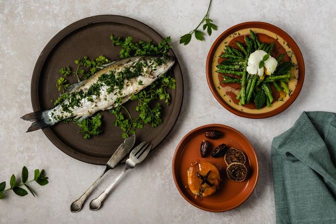 Een menu met drie gerechten: vis, groene asperges en dadels