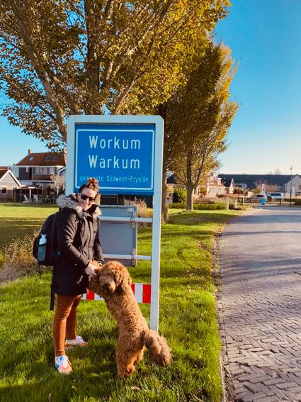 Lydia samen met hond Sjef bij het bord van Workum