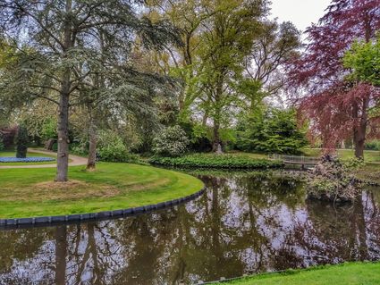 Uitkijken over het water met een bruggetje in de verte in het Wilhelminapark in Sneek.