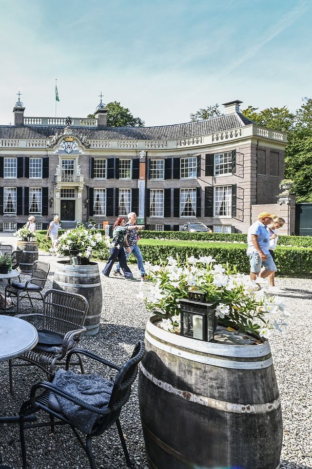 Mensen die in de zomer voor Kasteel Groeneveld langslopen