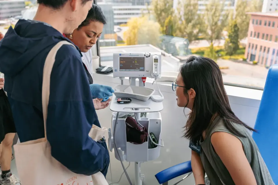 Vrouw laat bloeddruk meten in bijzijn van dokter