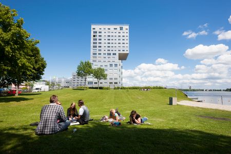 Mensen zitten in een parkje naast de Silverline in Almere Centrum.
