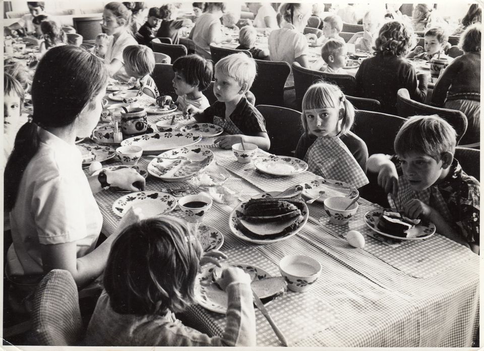 Zwart-wit foto van kinderen die zitten te eten aan een lange tafel in Kindertehuis Rustoord in Oisterwijk