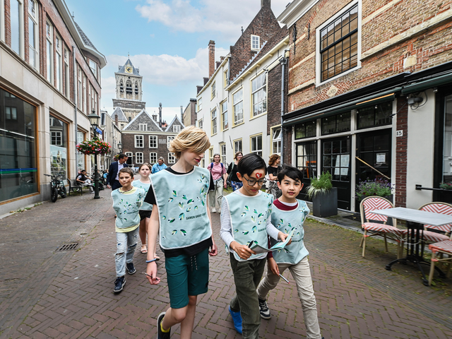 Kinderen lopend door de historische straten van Delft terwijl ze een kinderspeurtocht doen