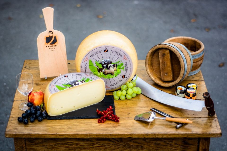 Een tafel met verschillende kazen en garnituur.