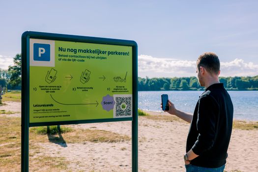 Man scant een QR-code om een uitrijkaartje te kopen.