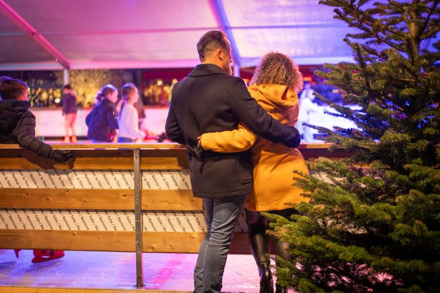 Een man een een vrouw die omhelzend bij de schaatsbaan kijken in Purmerend