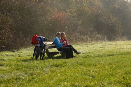 Mensen zitten op een bankje in de natuur.
