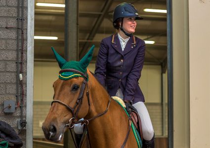 een vrouwelijke ruiter te paard in een manege