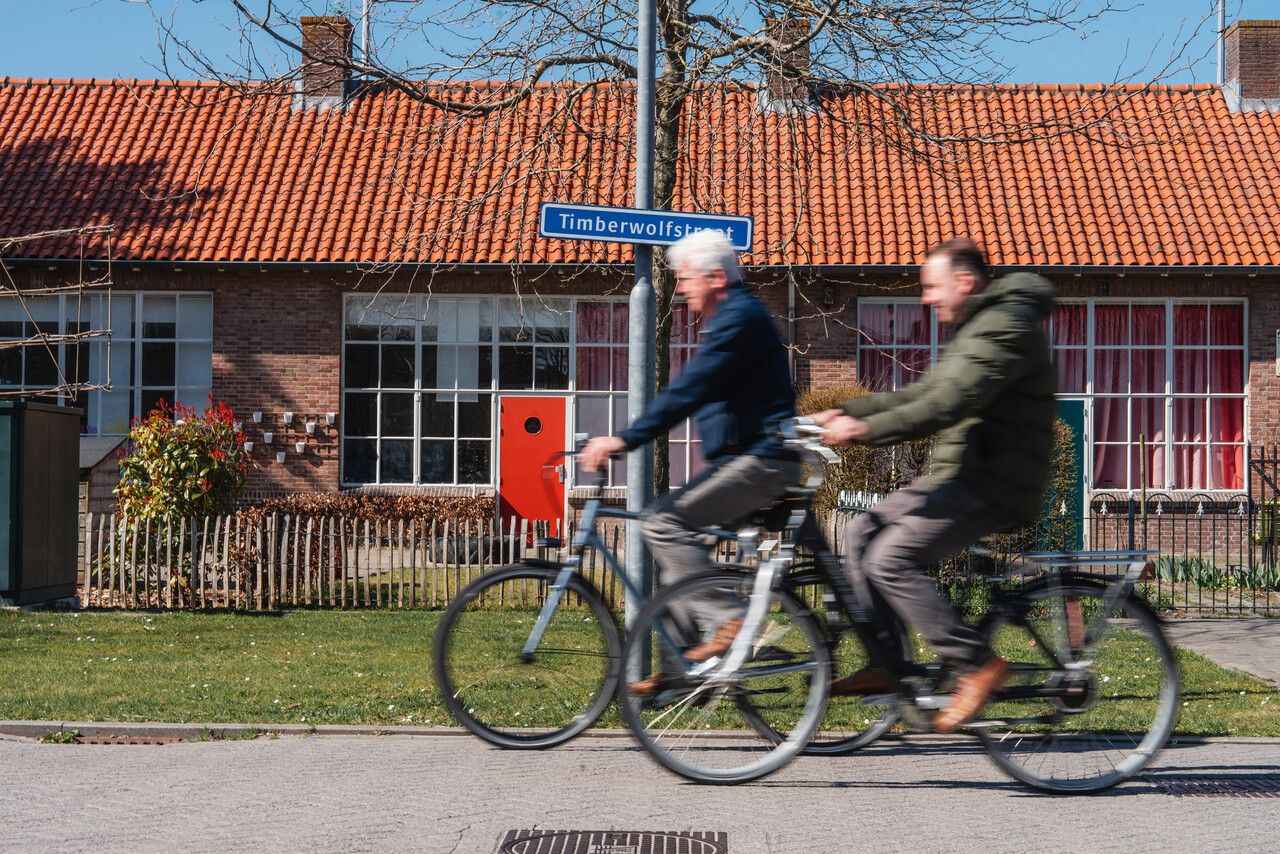 Fietsers fietsen door de Timberwolvesstraat in Standdaarbuiten