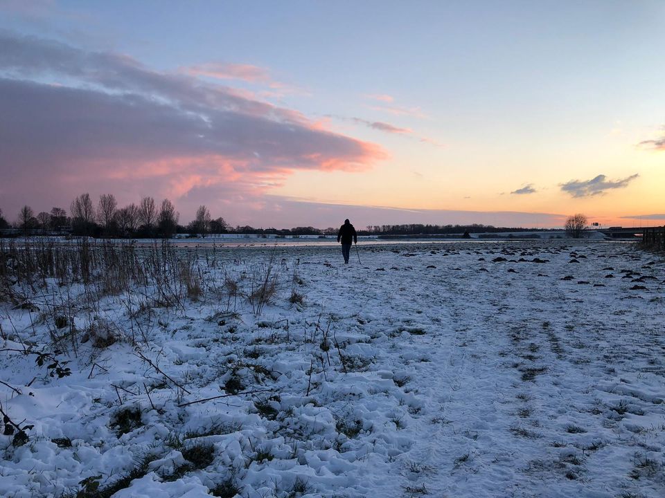 Zonsondergang bij de Uiterwaarden in winters landschap