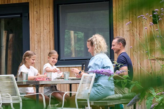 Een gezin van vier aan de buitentafel bij Boshuis Bambi in Oudemirdum.