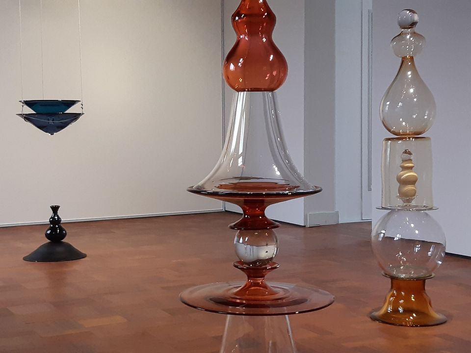 Drie glazen kunstwerken op en bruine vloer