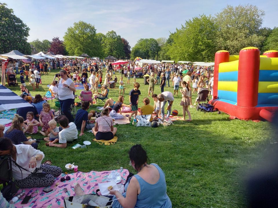 Een veld gevuld met kramen, mensen en springkussens