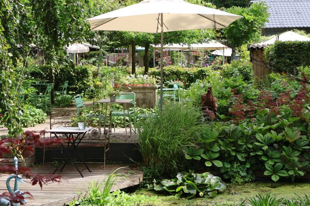 Het gezellige kleine terras in de groene tuinen van De Luie Tuinman.