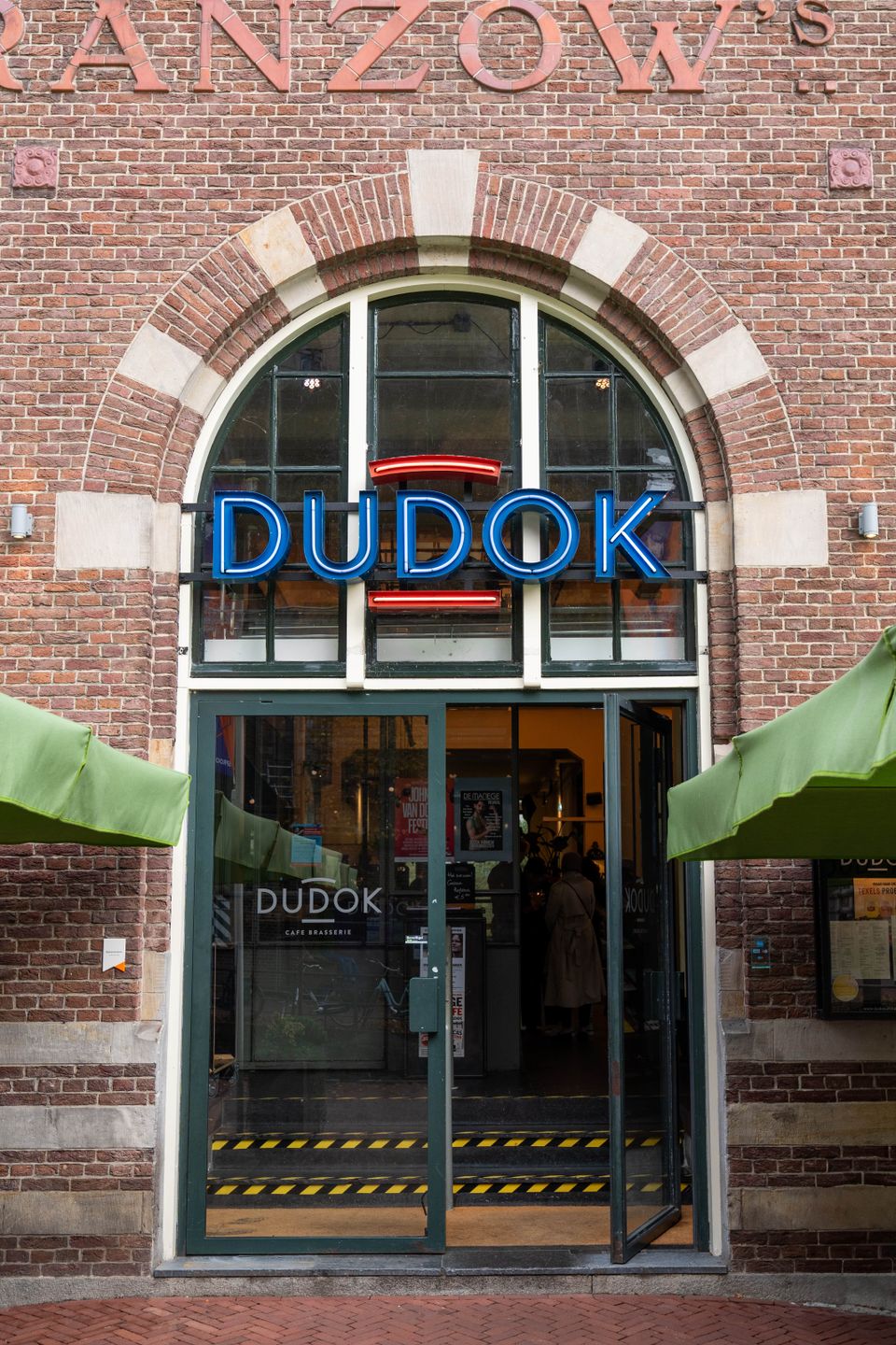 Een gastvrije entree naar ons restaurant, gekenmerkt door een groot bakstenen gebouw dat extra karakter toevoegt aan de eetervaring.