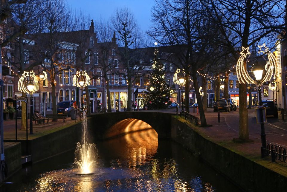 Stadsgezicht historisch centrum Oudewater, Oudewater, Groene Hart, avondbeeld met verlichte brug, fontein in de stadsgracht en sfeervolle kerstverlichting langs de bomen en gevels.