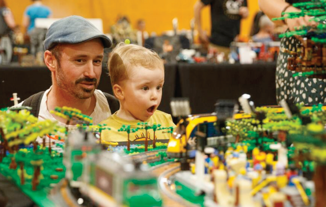 Vader en kind kijken naar lego bouwwerk