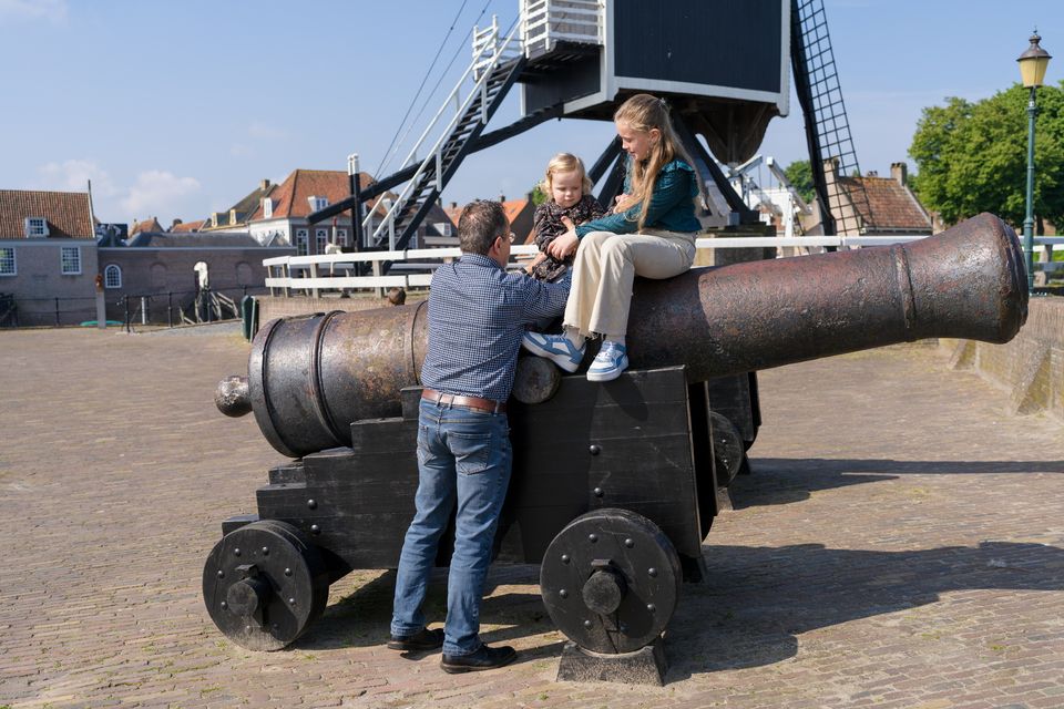 Een opa en zijn kleinkinderen bij een kanon en molen in Heusden