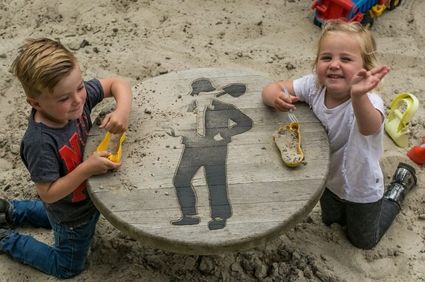 Twee kids spelen in de koloniespeeltuin