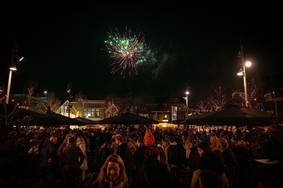 Vuurwerk in de lucht op de Koemarkt in Purmerend waarbij allemaal mensen kijken