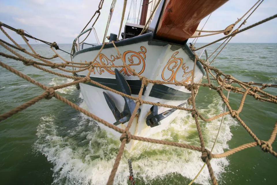 De neus van Hotelschip De Zevenwouden in Workum die door het water snijdt.