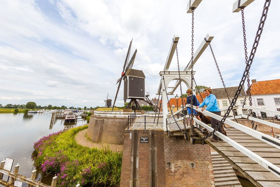 Walking Heusden, two people on the bridge at the mill