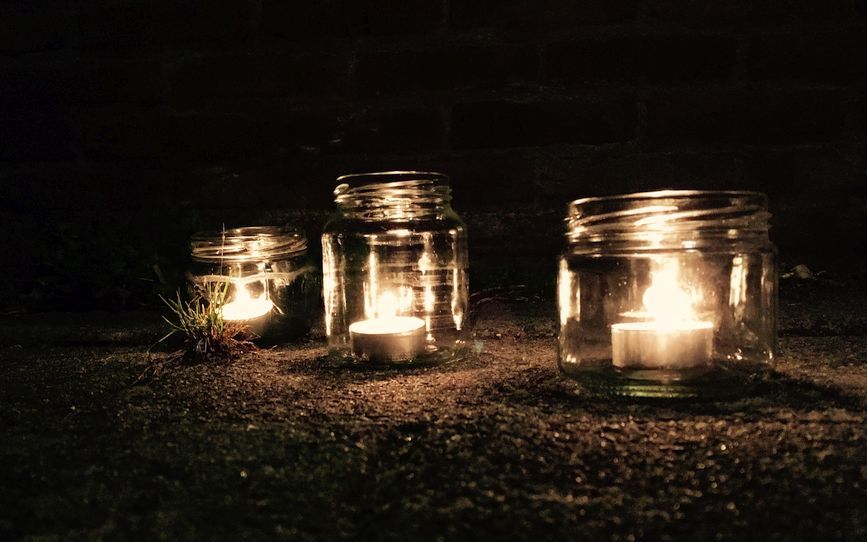 brandende waxine kaarsjes in een jampot wijzen de weg tijdens de Lichtjestocht